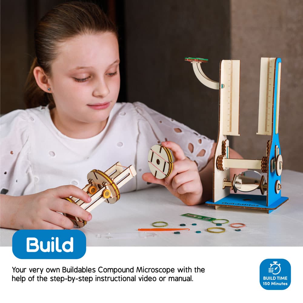 Child building the compound microscope model — hands-on STEM activity that develops fine motor skills and curiosity